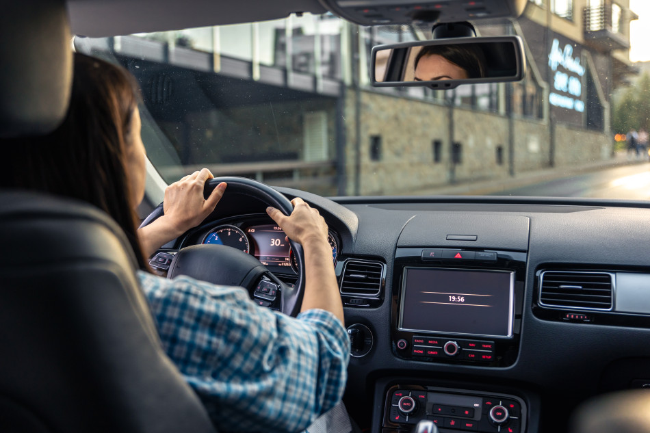 Women driving along empty city road