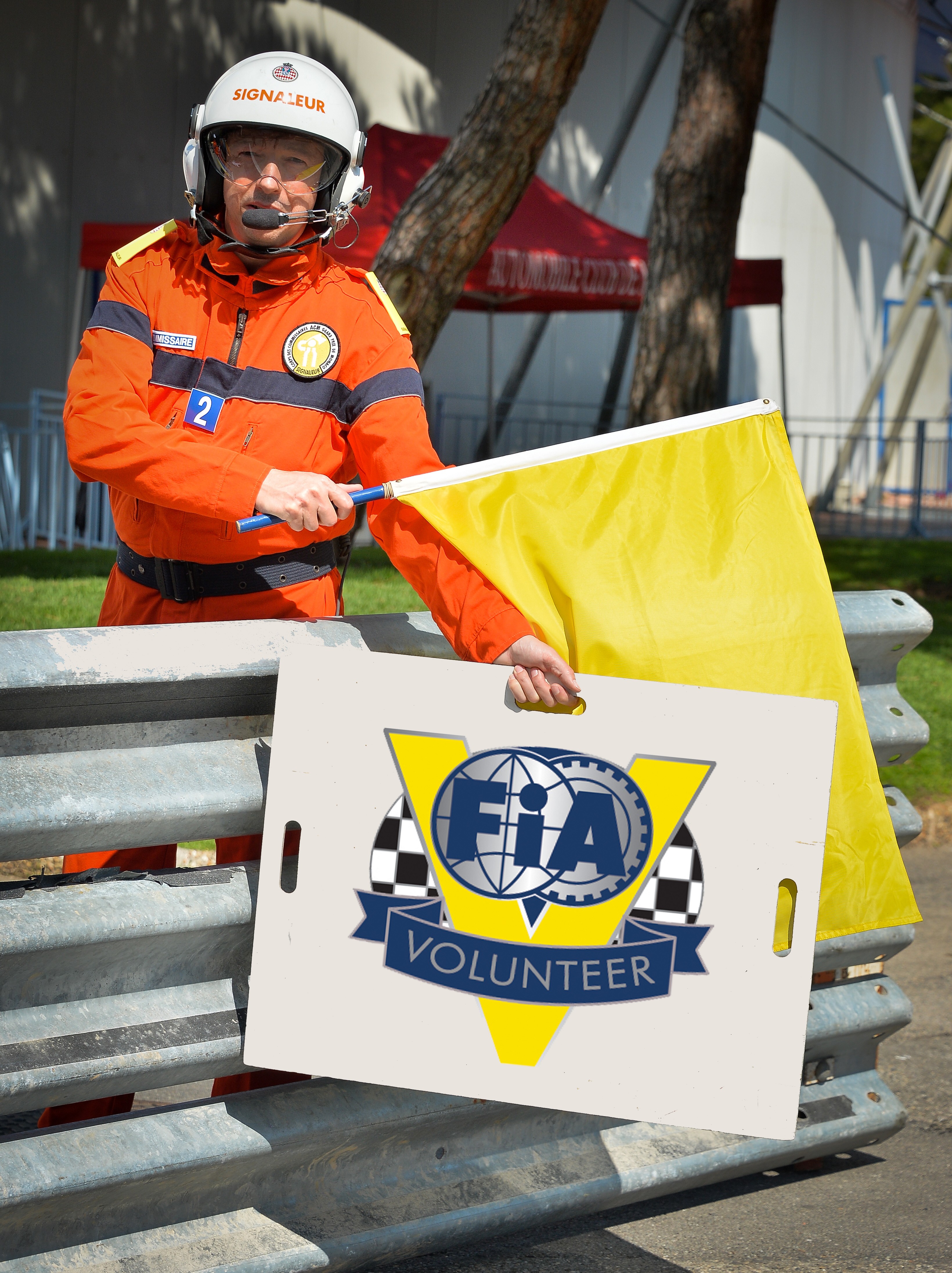 FIA official at circuit event displaying yellow flag.